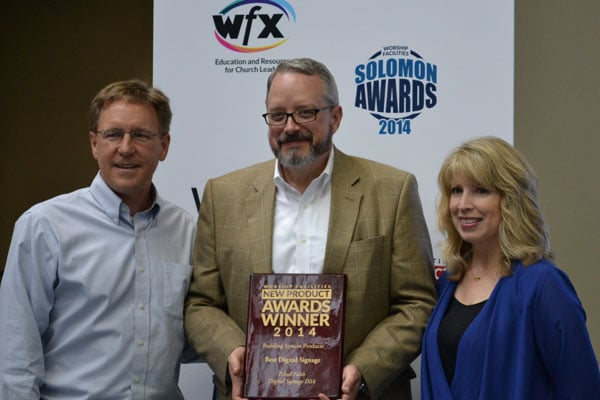 Piksel Faith’s VP of Sales, Alan Riley (center) accepts the Worship Facilities New Product Award for Digital Signage at WFX 2014.